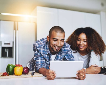 Photo for Couple, tablet and cooking food in kitchen at home with blog, internet website and online connection. Happy African man, woman and digital recipe for reading instruction of healthy vegetarian meal. - Royalty Free Image