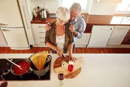 Photo for Affection, support or old couple kitchen cooking with love or healthy food for lunch together at home. Hug, embrace or above of senior woman helping an elderly romantic husband in meal preparation. - Royalty Free Image