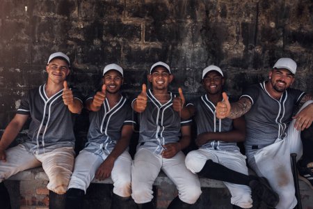 Foto de Cualquiera que sea la pregunta, la respuesta es el béisbol. un grupo de jóvenes jugadores de béisbol sentados en el dugout y mostrando los pulgares hacia arriba - Imagen libre de derechos