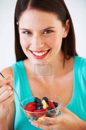 Photo for Woman, portrait and eating a healthy fruit salad with berries, nutrition and health benefits. Face of a happy female person on nutritionist diet with vegan food for weight loss, wellness or detox. - Royalty Free Image