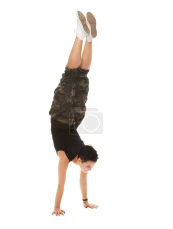 Téléchargez les photos : Ludique à l'envers. Studio shot d'une adolescente cool faisant un handstand isolé sur blanc - en image libre de droit