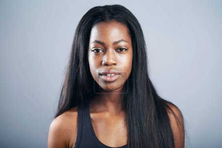 Téléchargez les photos : Modèle headshot, portrait et une femme noire confiante isolée sur un fond de studio. Jamaïque, posant et une jeune fille africaine aux cheveux longs pour le profil de modélisation avec confiance sur un fond. - en image libre de droit