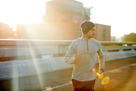 Foto de Salida del sol. un joven corredor salió a correr por la mañana temprano - Imagen libre de derechos