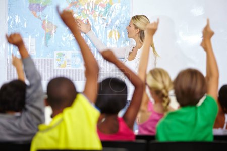 Photo for They all know the answer. school kids raising their hands to answer a question during a lesson - Royalty Free Image