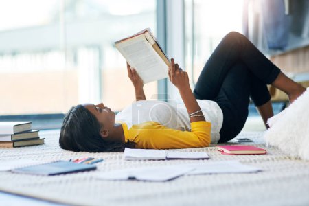 Photo for Books, relax student and woman reading literature, research or book for home school education, study or college. Learning commitment, university and person studying knowledge while lying on floor. - Royalty Free Image
