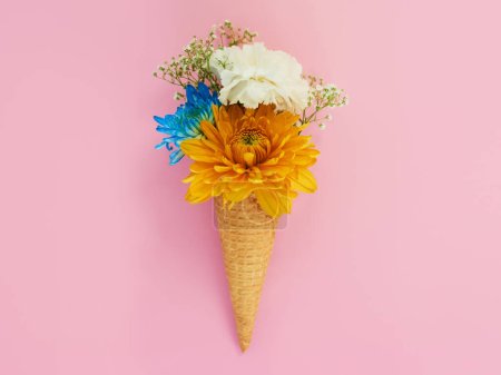 Téléchargez les photos : Fleurs, cône et crème glacée dans un studio de décoration, de créativité ou d'art avec bouquet frais et coloré. Plantes florales créatives, mortes et florales dans un dessert isolé par un fond rose - en image libre de droit