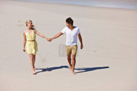 Foto de Serás mi amor de verano. una feliz pareja joven disfrutando de un romántico paseo por la playa - Imagen libre de derechos