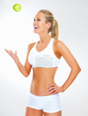 Photo for Living well with a healthy diet. Studio shot of an attractive young woman in exercise clothing against a gray background - Royalty Free Image