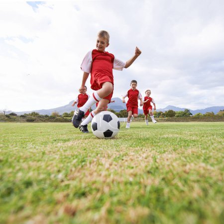 Photo for Running, kick and sports with children and soccer ball on field for training, competition and fitness. Game, summer and action with football player on pitch for goals, energy and athlete. - Royalty Free Image