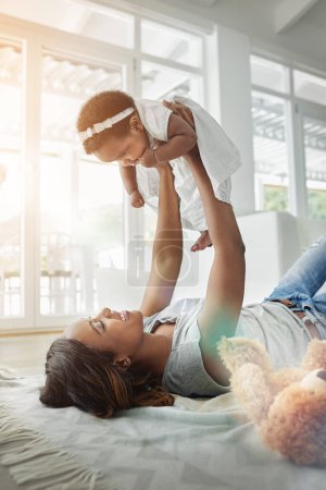 Photo for Happy black woman, baby and playing on floor with love, teddy bear and smile together in living room. Happiness, mother and daughter in flying bonding, quality time for parent and newborn in home - Royalty Free Image