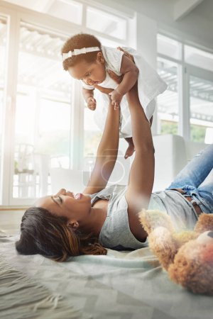 Photo for Bonding, black woman and baby playing on floor with love, happiness and happy time together in living room. Smile, mother and daughter in playful embrace, laughing parent and newborn in family home - Royalty Free Image