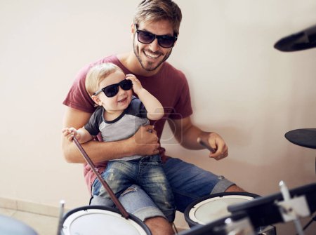Photo for Cool father, baby sunglasses and drummer musician with music development and child learning. Home, happiness and dad with youth drumming lesson with smile, love and parent care at a family house. - Royalty Free Image