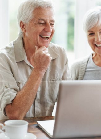 Téléchargez les photos : Heureux couple de personnes âgées, ordinateur portable et connexion à la maison pour les achats en ligne, recherche sur Internet et blog de site Web. Vieil homme, femme et rire sur ordinateur pour les médias sociaux, nouvelles numériques drôles et la technologie. - en image libre de droit