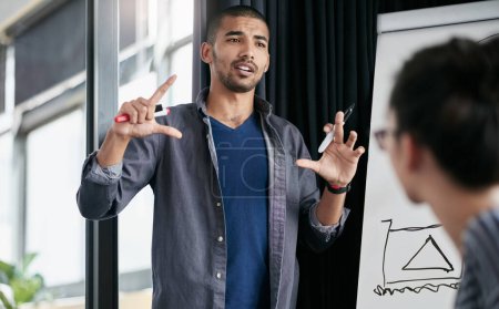 Foto de Presentando su visión de los negocios. un hombre dando una presentación de pizarra blanca a sus colegas en una oficina - Imagen libre de derechos