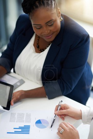 Téléchargez les photos : Femme noire en réunion d'affaires, analyse de données et étude de marché avec collaboration, analyse de graphiques et d'équipe. Papier, tableau d'information d'examen et employées travaillant ensemble au bureau. - en image libre de droit