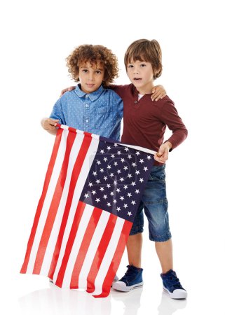Photo for Pals in patriotism. Studio shot of two cute little boys holding the American flag together against a white background - Royalty Free Image