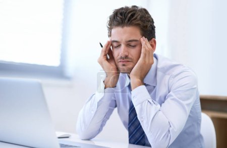 Photo for Ive got way too much work to do...a stressed-out businessman sitting at his desk - Royalty Free Image