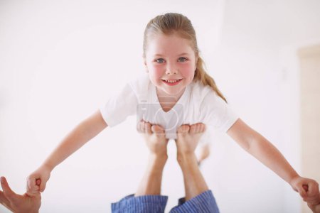 Photo for She knows Daddy wont ever let her fall. Portrait of a young girl propped up on her fathers feet - Royalty Free Image