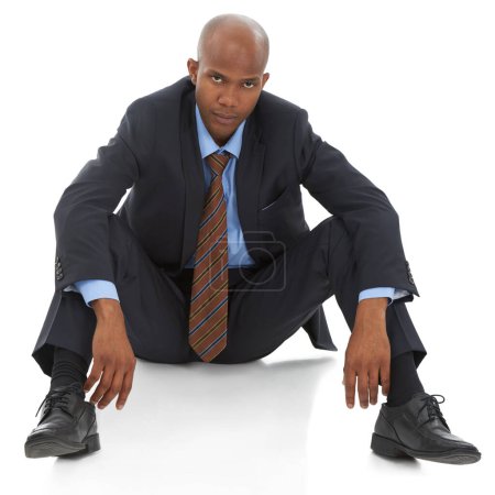 Téléchargez les photos : Le travail lui a tout enlevé... Un jeune homme d'affaires afro-américain assis avec découragement sur un fond blanc - en image libre de droit