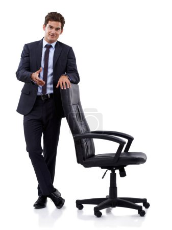 Foto de Pasa, siéntate. Un joven empresario haciendo un gesto hacia una silla - Imagen libre de derechos