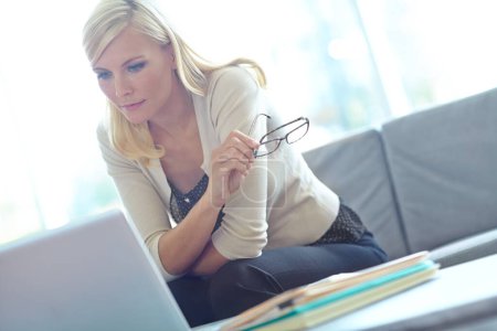 Photo for Reviewing her notes on her business proposal. a beautiful business woman looking at her laptop in her office with copyspace - Royalty Free Image
