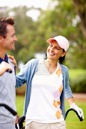 Téléchargez les photos : Couple souriant sur le terrain de golf. Couple souriant debout sur le terrain de golf et se regardant - en image libre de droit