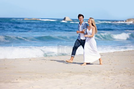 Foto de Feliz luna de miel. una feliz pareja joven disfrutando de un romántico paseo por la playa - Imagen libre de derechos