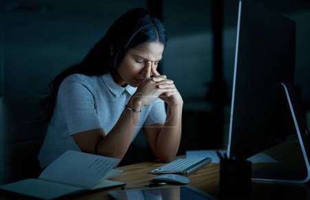 Photo for Sometimes we need to fall apart to rebuild again. a young businesswoman looking stressed while using a computer during a late night at work - Royalty Free Image