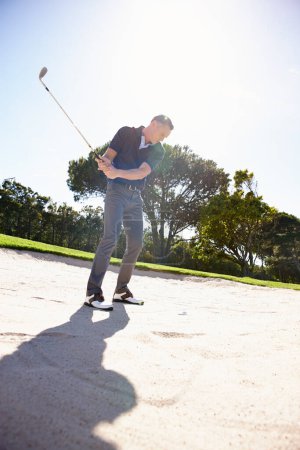 Photo for Placing all of his focus on the ball. a handsome mature man playing a game of golf - Royalty Free Image