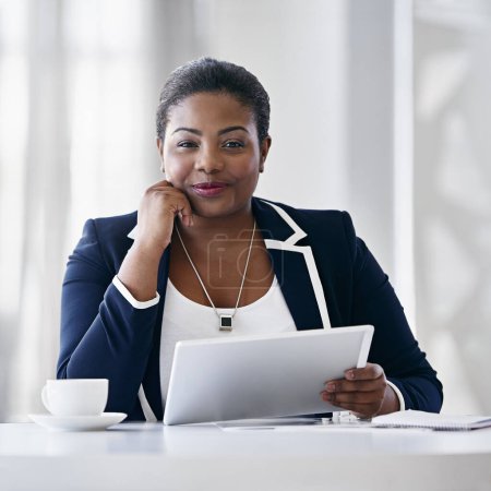 Foto de Se centró en el éxito. Retrato de una joven empresaria usando una tableta digital mientras está sentada en un escritorio en una oficina - Imagen libre de derechos