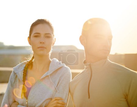 Foto de Estaban cien por ciento enfocados en esta carrera. Retrato de dos corredores de pie contra el sol de la mañana - Imagen libre de derechos