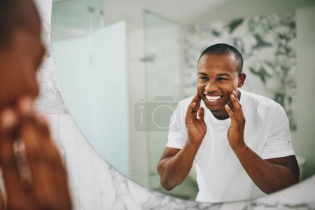 Téléchargez les photos : Joyeux matin et miroir avec homme noir dans la salle de bain pour la beauté, les soins de la peau et le toilettage. Nettoyage, hygiène et auto-soin avec réflexion de la personne masculine à la maison pour le visage, naturel et bien-être. - en image libre de droit