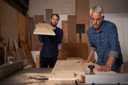 Photo for Carpentry, carpenter and men in workshop work on design project with team, vocation and creative DIY skill. Teamwork, collaboration and male employee saw wood with father and son working together. - Royalty Free Image
