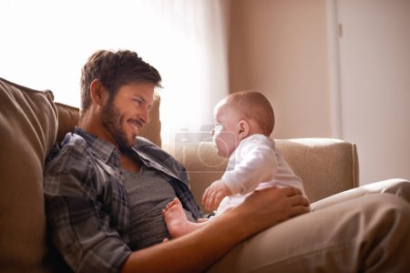 Photo for Smile, father and baby sitting on lap on sofa in home living room, bonding or playing together. Happiness, care and dad with newborn child on couch in lounge, having fun and enjoying relax time - Royalty Free Image