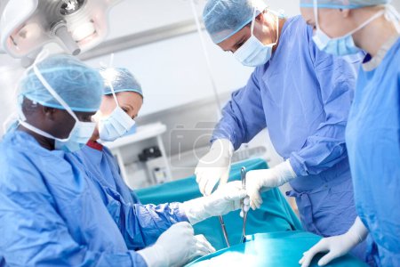 Photo for We know everything there is to know about the human body. Group of doctors and surgeons working on a patient in an operating theatre - Royalty Free Image