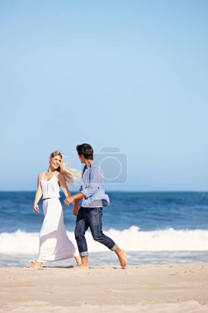 Téléchargez les photos : La vie est belle avec toi dedans. un jeune couple heureux profitant d'une promenade romantique sur la plage - en image libre de droit