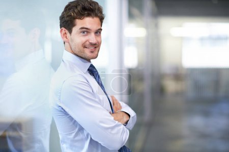 Foto de Soy el hombre de negocios que necesitas. un joven hombre de negocios guapo parado en la oficina - Imagen libre de derechos