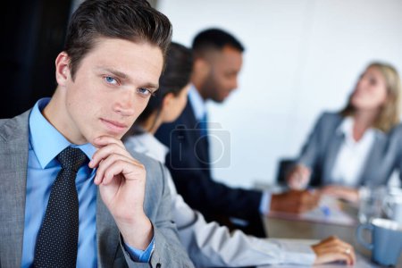 Téléchargez les photos : J'ai un plan. Portrait d'un jeune homme d'affaires assis dans la salle de réunion avec ses collègues lors d'une réunion - en image libre de droit