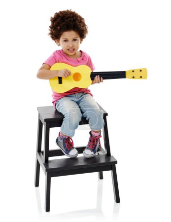Téléchargez les photos : Puis-je répondre à vos demandes ? Plan studio d'une jolie petite fille jouant avec sa guitare jouet sur fond blanc - en image libre de droit