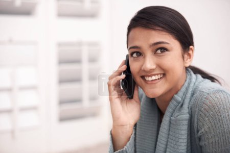 Photo for Catching up on the news of their day. An attractive young woman talking on her cellphone - Royalty Free Image