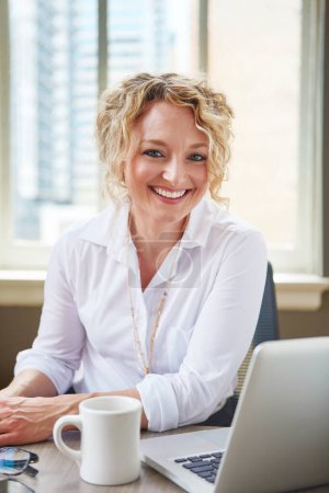 Téléchargez les photos : Avez-vous vu le nouveau site de mon entreprise ? Portrait d'une femme d'affaires travaillant à son bureau dans un bureau - en image libre de droit