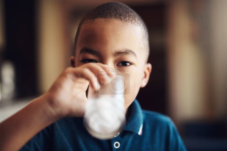 Foto de Todos, incluidos los niños, deberían beber mucha agua. un niño bebiendo un vaso de agua en casa - Imagen libre de derechos