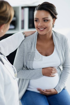 Photo for Pregnant woman, smile and doctor in a hospital at baby check up with happiness. Stomach, pregnancy and healthcare with a professional in clinic with a African female patient in wellness consultation. - Royalty Free Image