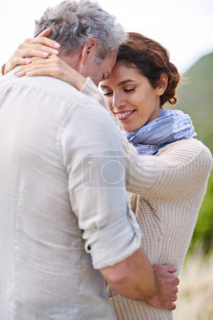 Photo for Sharing a tender moment. Sideways shot of a mature loving couple standing face to face and hugging - Royalty Free Image