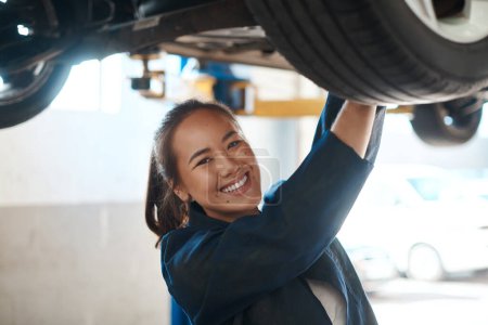 Photo for Theres always a car that needs fixing. a female mechanic working under a lifted car - Royalty Free Image