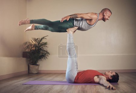 Foto de Trabajando esas piernas. Largometraje de un joven guapo haciendo acro yoga con su pareja en un estudio de yoga - Imagen libre de derechos
