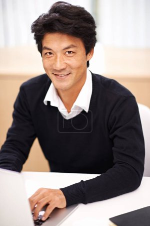 Photo for Ready to tackle the work. Portrait of a handsome asian businessman working on his laptop in the office - Royalty Free Image
