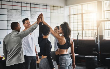 Photo for Go team go. a group of young people giving each other a high five during their workout in a gym - Royalty Free Image