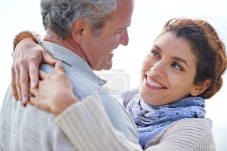 Foto de Tanto amor después de tantos años. Vista trasera de un hombre maduro siendo abrazado por su esposa al aire libre - Imagen libre de derechos