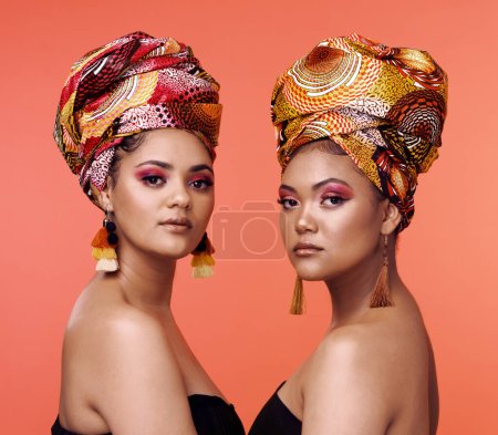 African fashion, beauty and portrait of women on orange background with cosmetics, makeup and accessories. Glamour, studio and face of female people with exotic jewelry, traditional style and luxury.